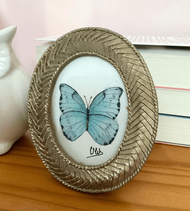 Papillon bleu irisé dans son cadre miniature doré